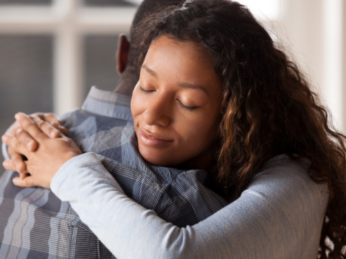 A young woman hugs her partner who is experiencing a substance abuse problem. She is using tips to help her partner and support him.