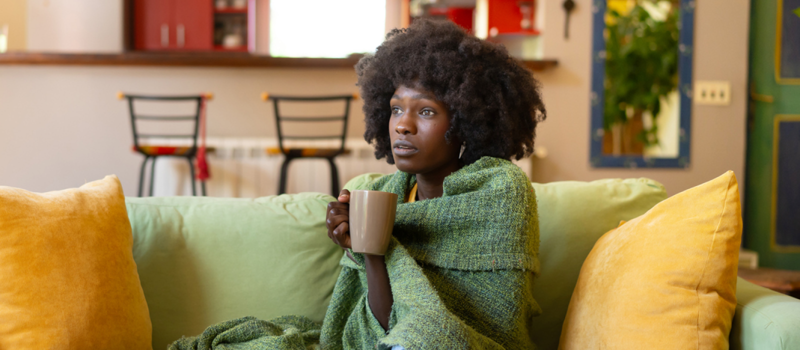 A young woman sits on the couch knowing that her mood is more than just the holiday blues.