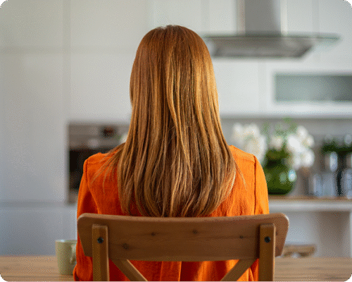 Woman sitting in her kitchen reflecting on her sexual assault experience and figuring out which therapy to start