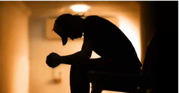 Person sitting in hallway by themself struggling with depression