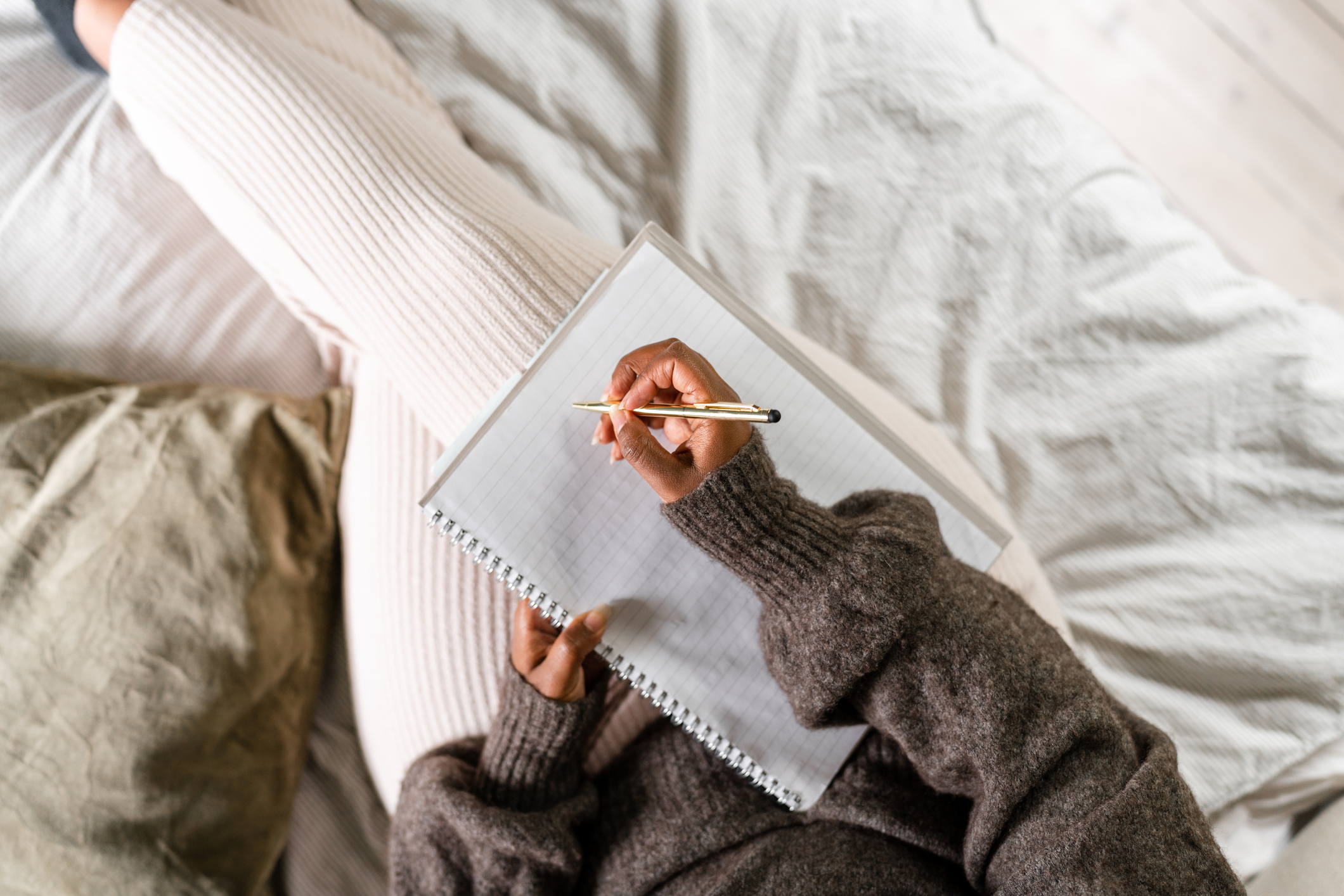 Woman sitting on bed, ready to write about her experiences with OCD.