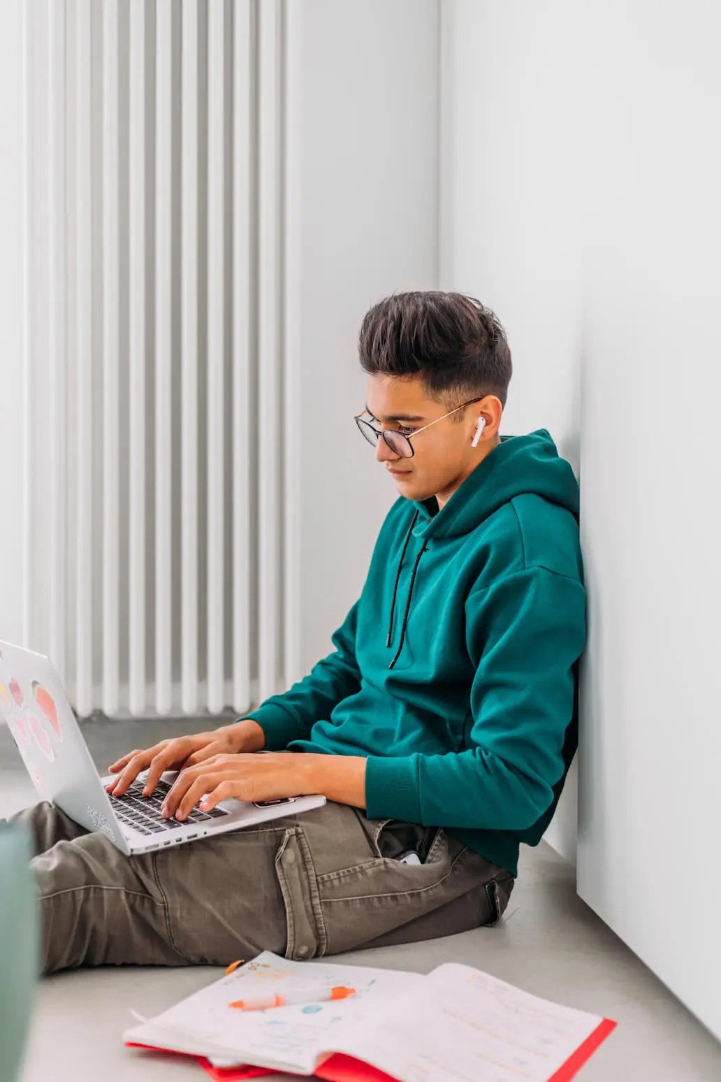 male teen working on schoolwork on his laptop