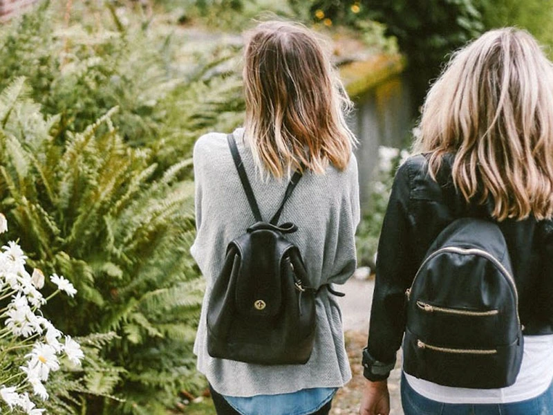 Two teens walk home from school together