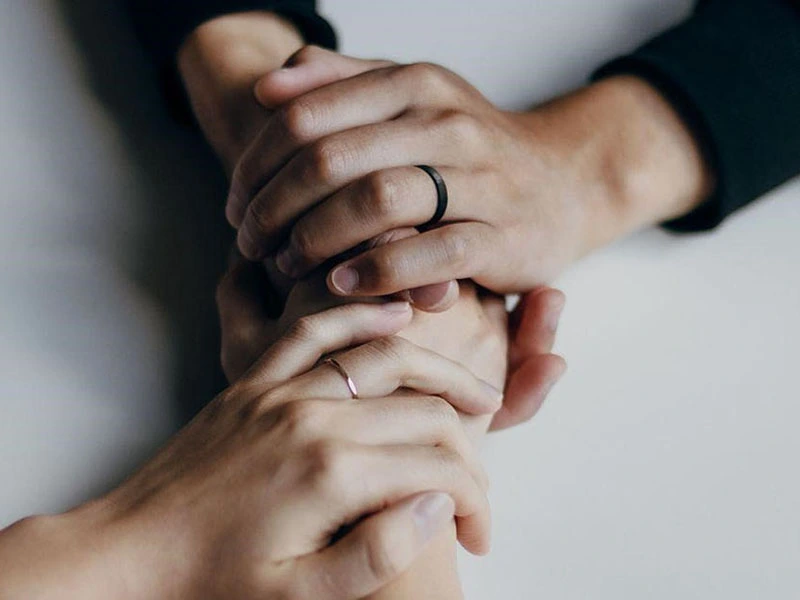 Two people grasping hands in substance abuse therapy