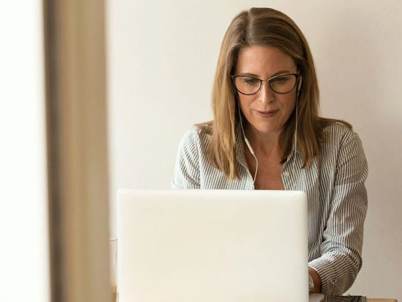 A mom sits at her laptop researching how to support her teen