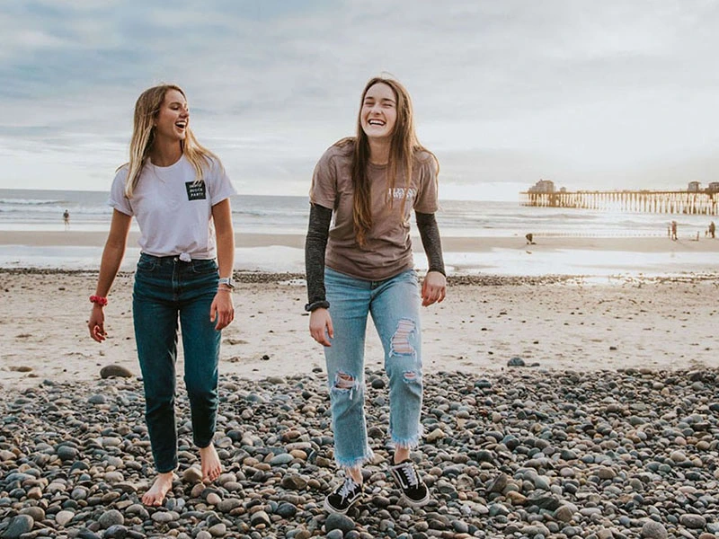 women walking on the beach to take a break from social media