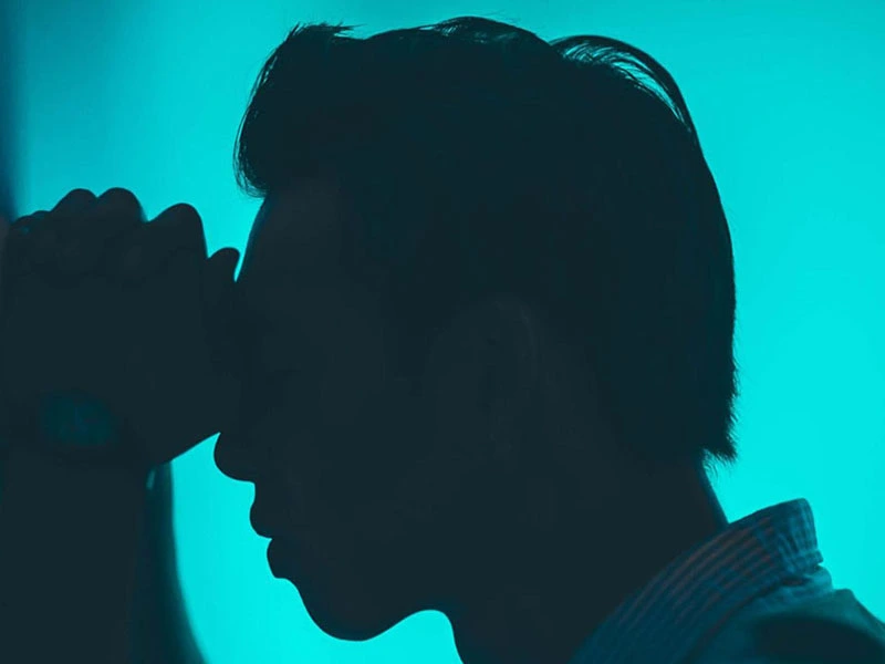 Man clasping his hands in pain