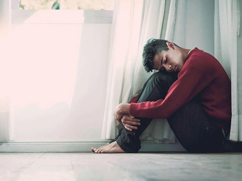 teenage boy isolating himself in a corner