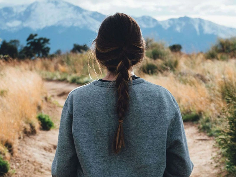 woman outside on a trail practicing self care