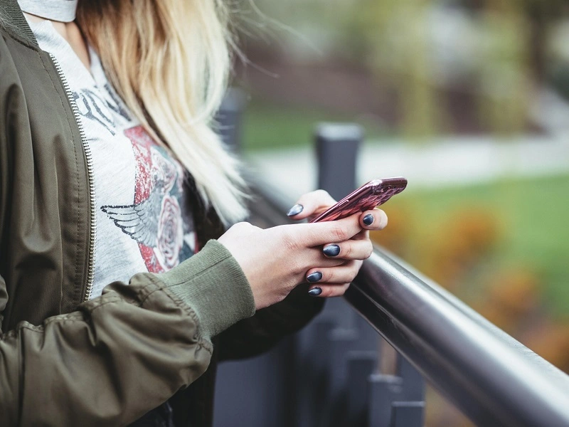 young woman texting the updated suicide hotline