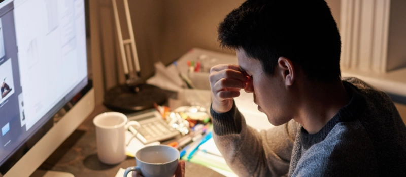 Student stressed working on school work grabbing his nose 