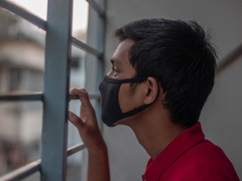 A young person at home during the pandemic wearing a mask