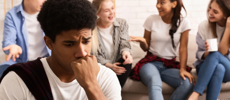 A teen male avoids his friends and relationships while sitting alone