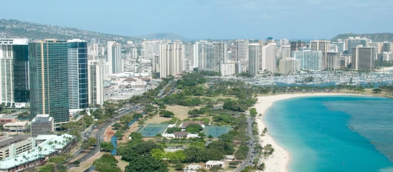 An aerial view of a beach and buildings in Honolulu.