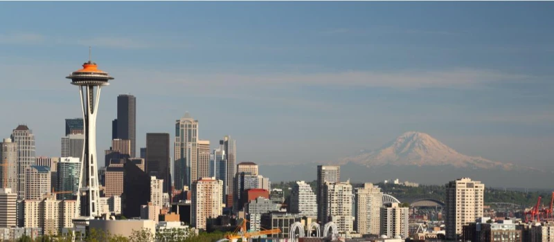 The Seattle skyline near sundown, featuring the Space Needle and Mt. Rainier.