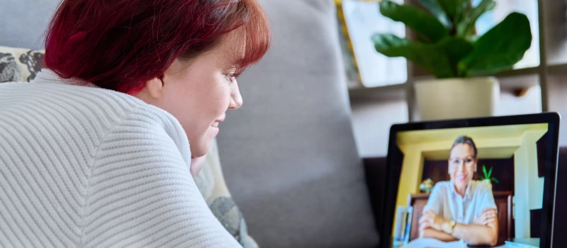 A teen with red hair attends a virtual IOP therapy session