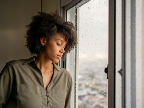 A woman with monophobia stares out of her window