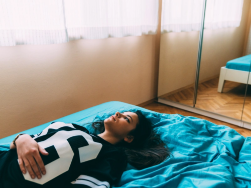 A teen girl lays in her bedroom struggling with complex trauma