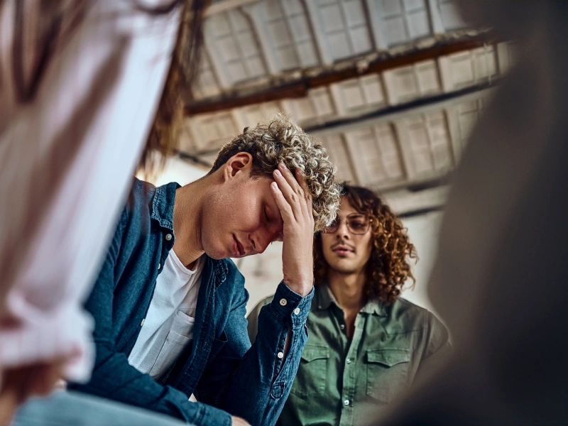 A teen with blonde hair struggles with acute stress disorder and his friend comforts him