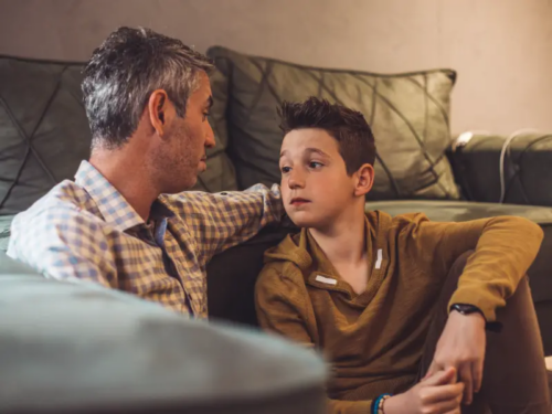 A father comforts his young teenage son who is struggling with trauma