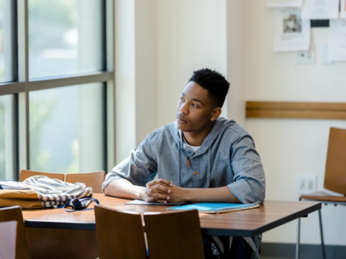 A young man sits at a desk before therapy