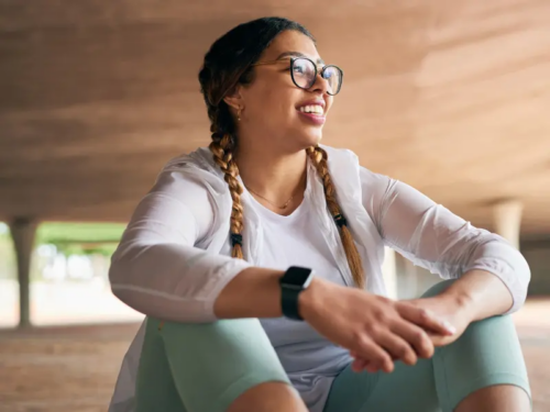 A young teen girl in glasses smiles after starting trauma informed therapy