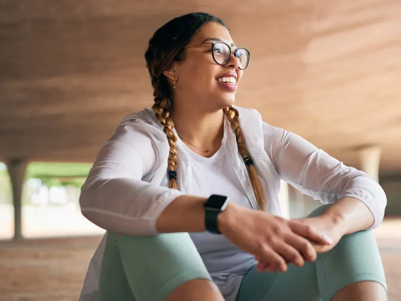 A young teen girl in glasses smiles after starting trauma informed therapy