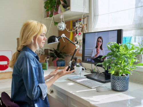 A teen dealing with trauma sits on her computer completing virtual trauma informed therapy