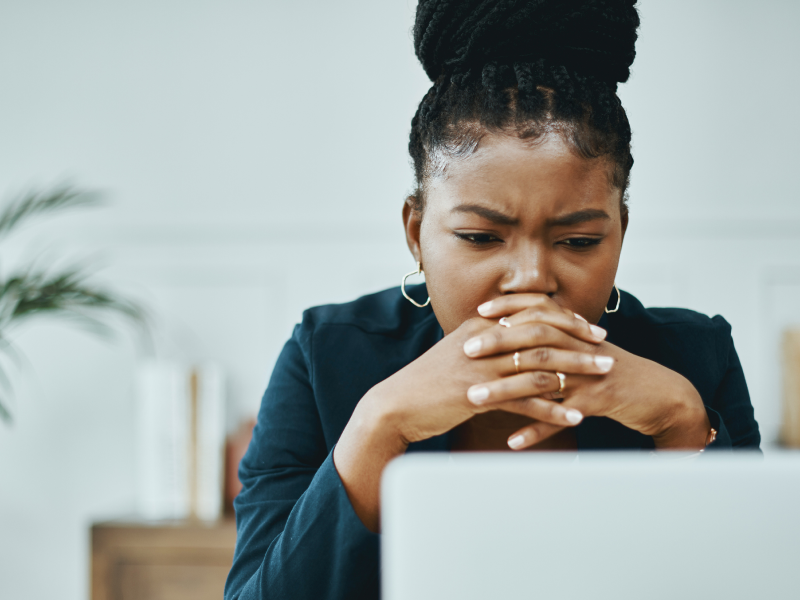 A young woman sits at her computer dealing with an anxiety attack