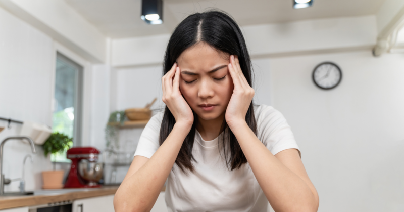 Young woman sits with head in hands processing trauma