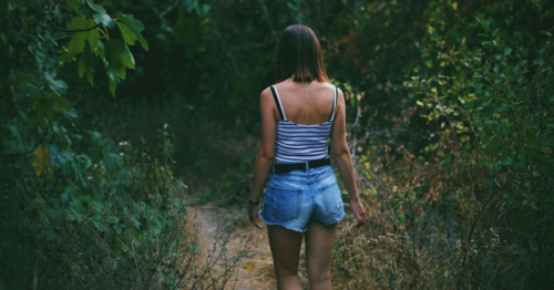 woman entering the woods for a hike in spring