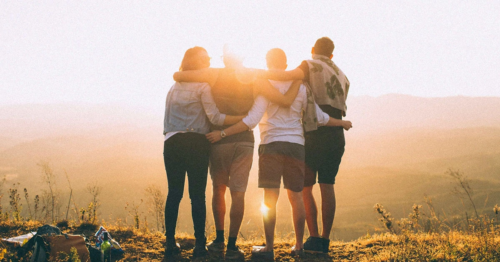 Four people hugging in a group therapy session