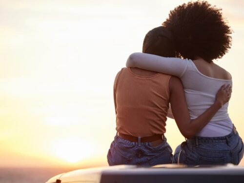 Two young adult female friends hug each other