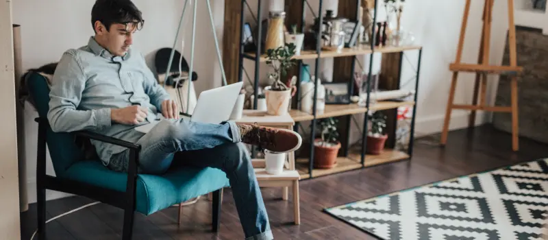 A young adult male sits in his apartment researching mental health