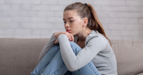 Woman sitting by herself looking sad