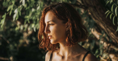 A teen girl in tree looking towards the ground depressed