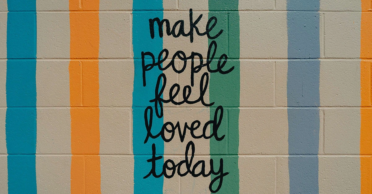 Wall with the words make people feel loved today on it