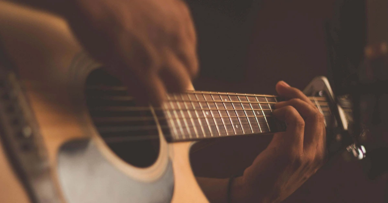 Person playing an acoustic guitar