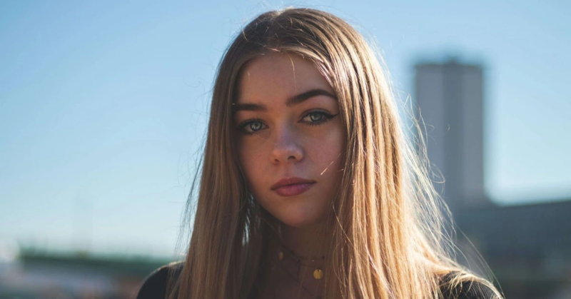 A woman looking into the camera trying to smile