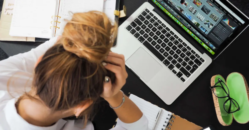 A young woman panics in front of her computer screen