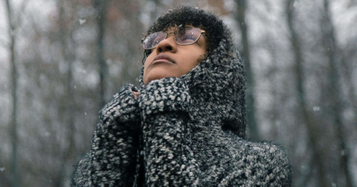 Person standing in the snow looking sad