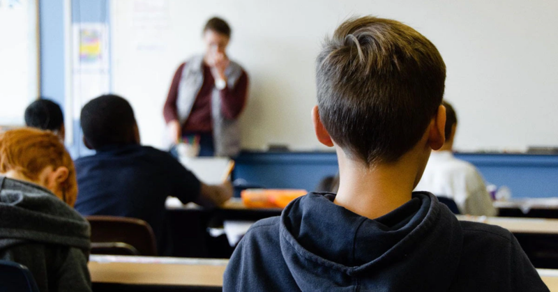 Students trying to focus on teacher delivering a lesson