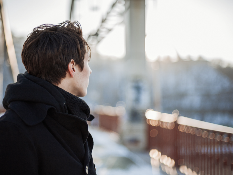 A young man stares off into the distance thinking about his fear of commitment