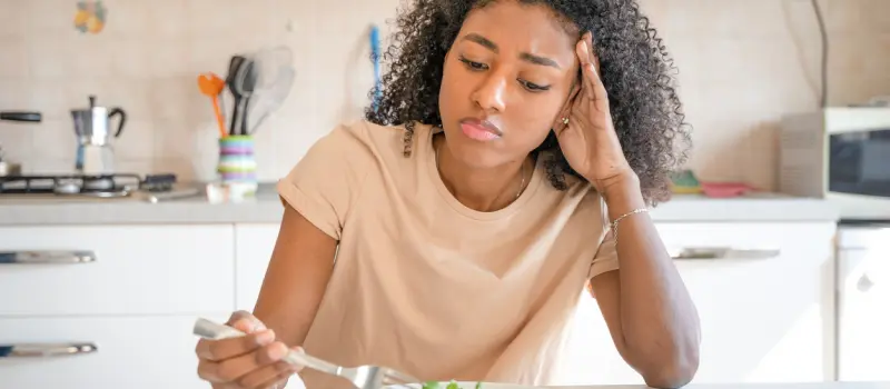 Female teen with an eating disorder eating a meal