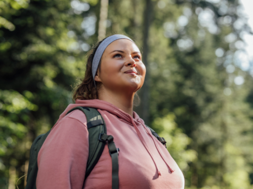 A woman who previously struggled with anxiety stands outside with a smile on her face