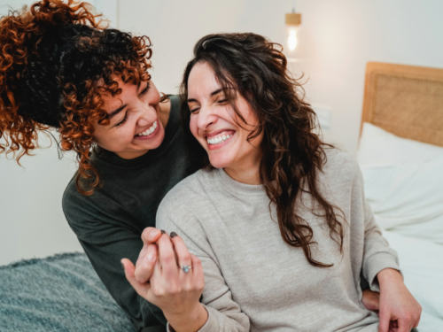 Someone coping with BPD sits smiling hand-in-hand with their Favorite Person.