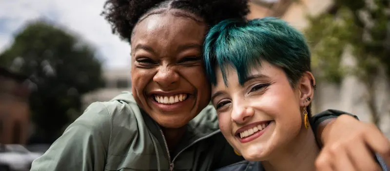 A set of two friends hug after healing from depression affecting their relationship