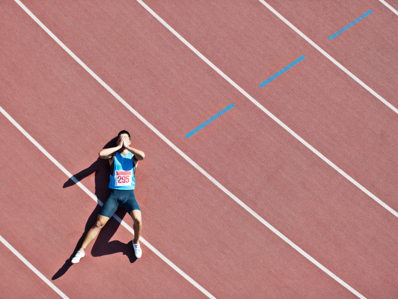 Runner laying on track dealing with depression