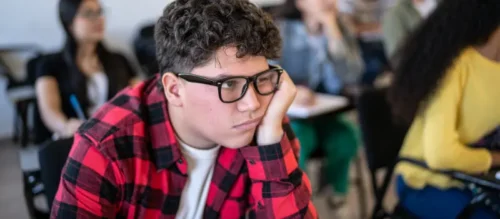 A child sits in class having a hard time controlling his bipolar-related anger.