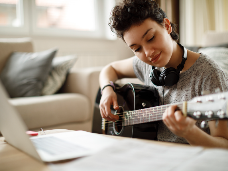 Teen playing his guitar for online music therapy